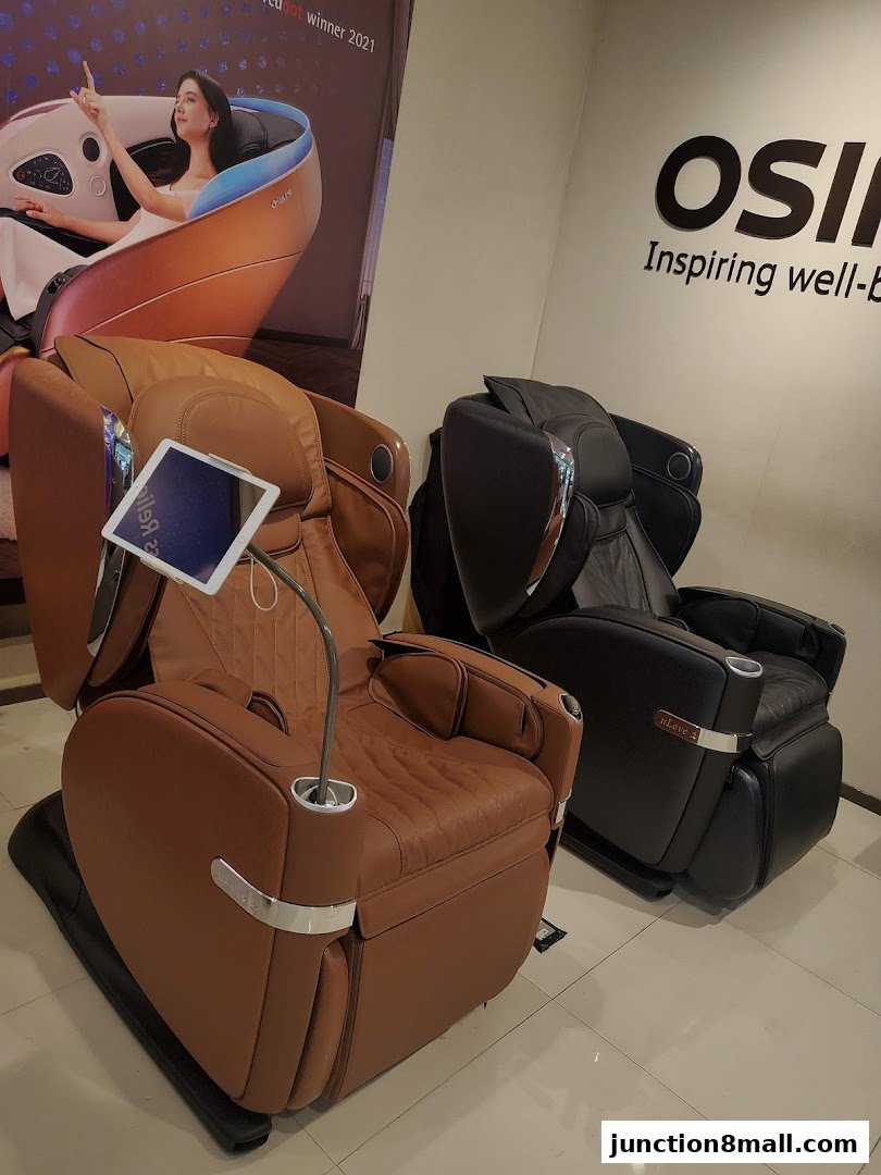 Two OSIM massage chairs, one brown and one black, are displayed in a store.
