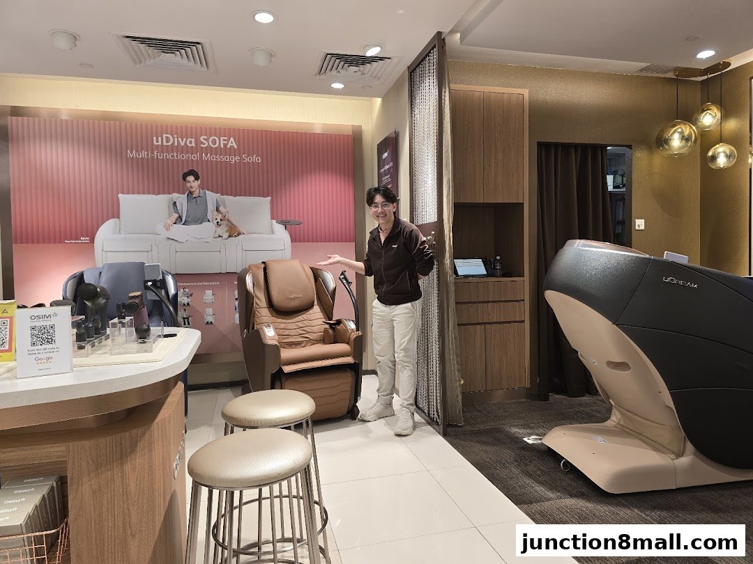 A person stands in an OSIM store showcasing massage chairs and a massage sofa.