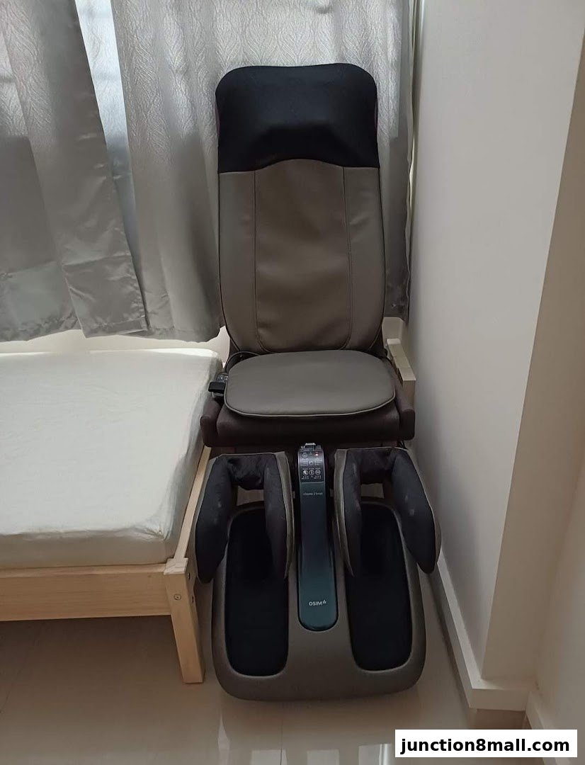 A massage chair with a foot massager attachment is shown next to a bed.