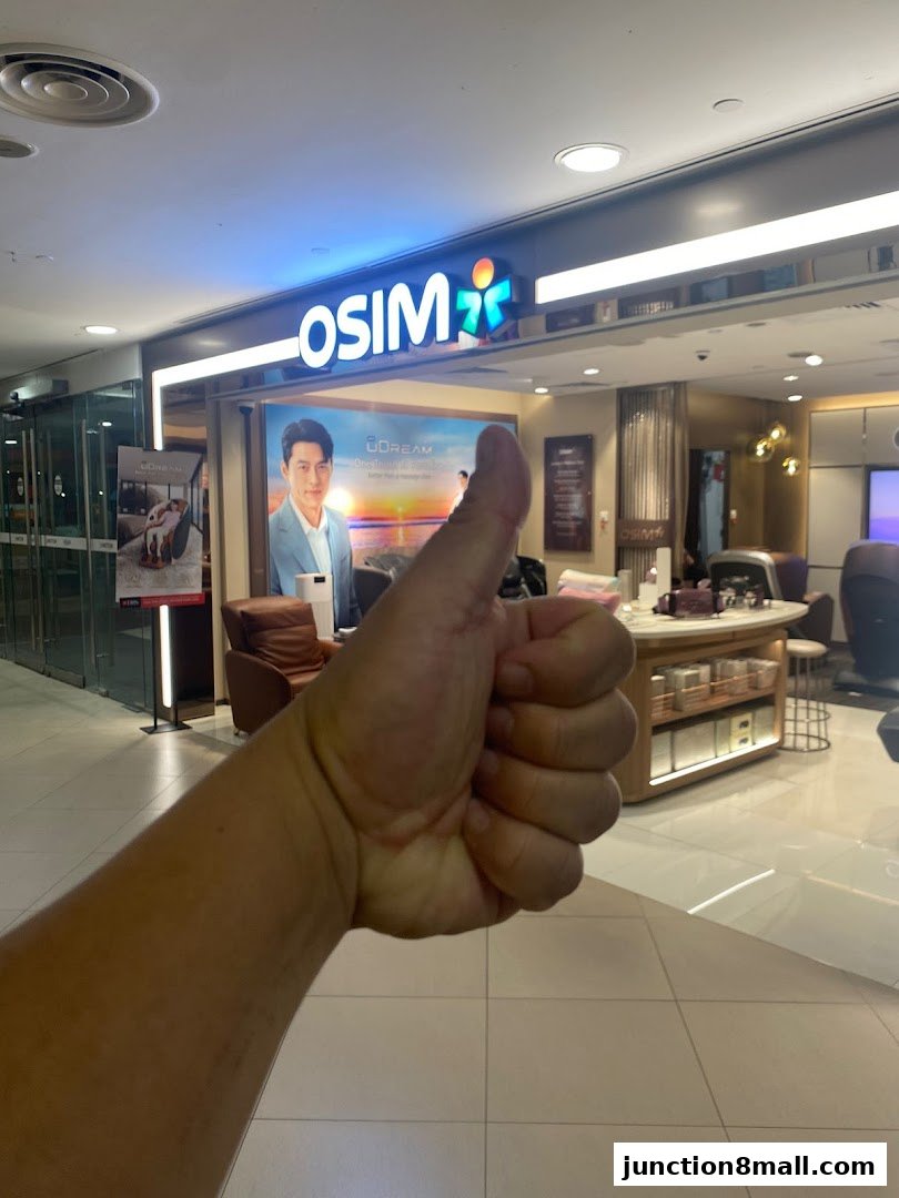 A hand gives a thumbs up in front of the OSIM store.