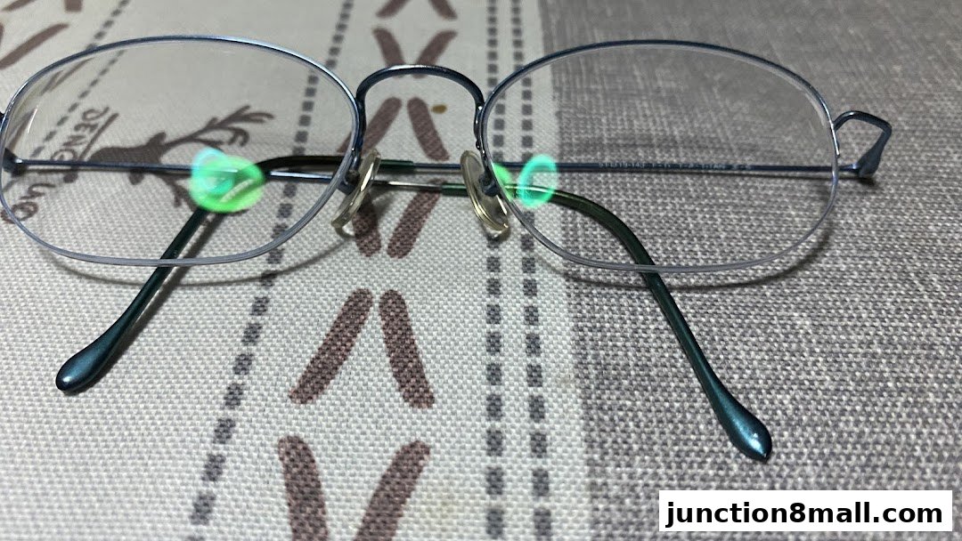 A close-up shot of stylish, thin-rimmed eyeglasses resting on a textured surface.