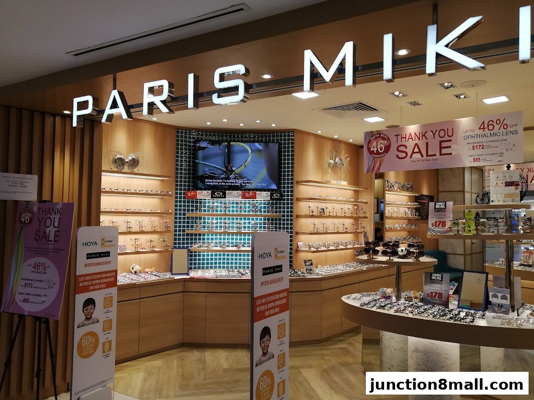Paris Miki optical shop interior with displays of spectacles, sunglasses, and promotional sale banners.