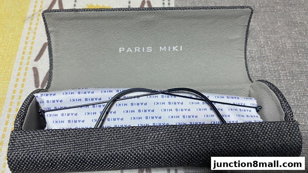 A pair of glasses rests inside a Paris Miki branded glasses case.