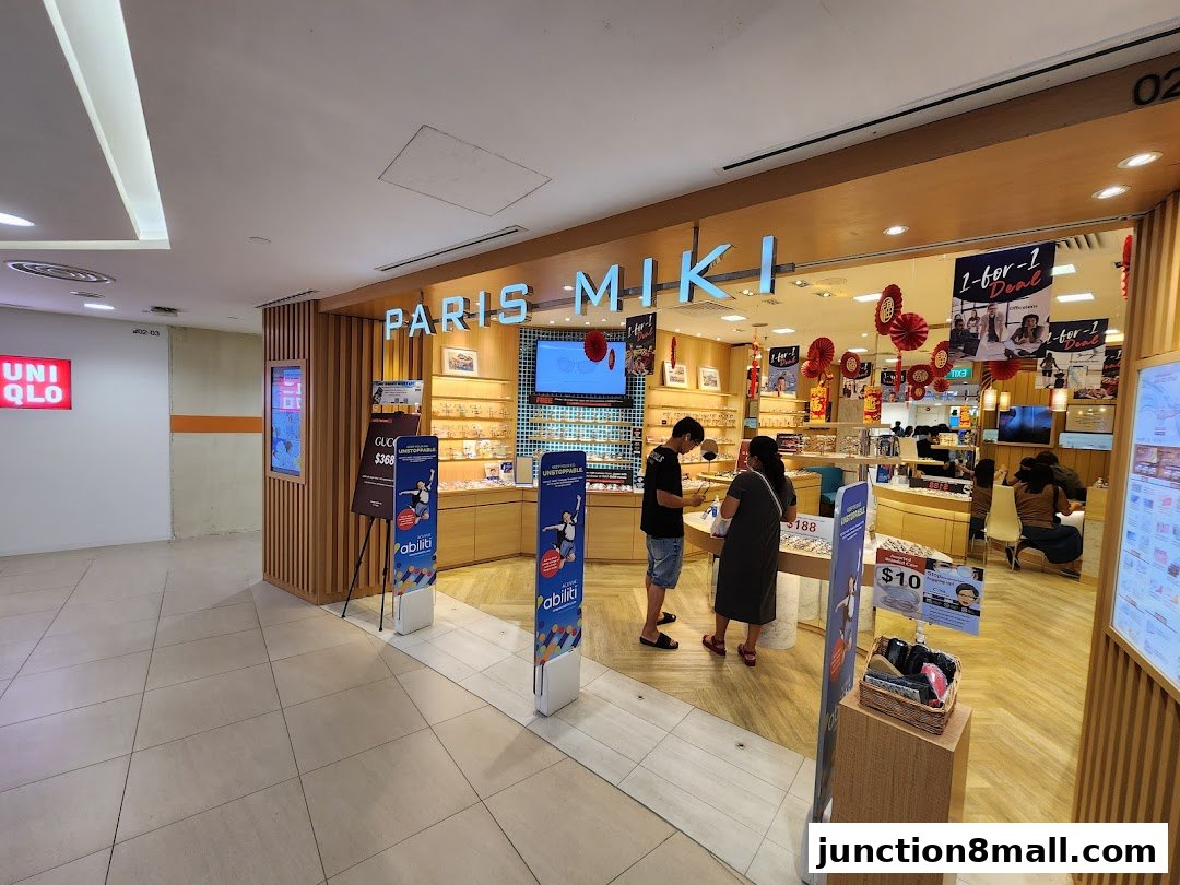 Paris Miki optical shop with customers browsing spectacles and promotional displays.