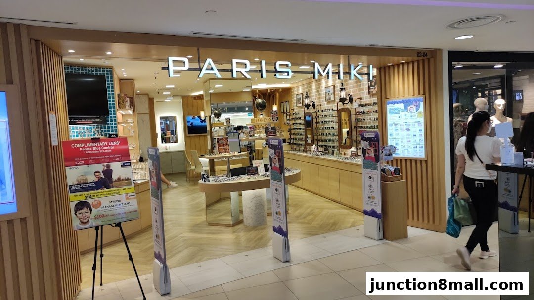 The entrance of Paris Miki, an optician shop, displaying spectacles and promotional posters.