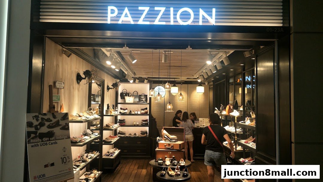 The entrance of PAZZION Junction 8 shoe store, showcasing various footwear and handbags.