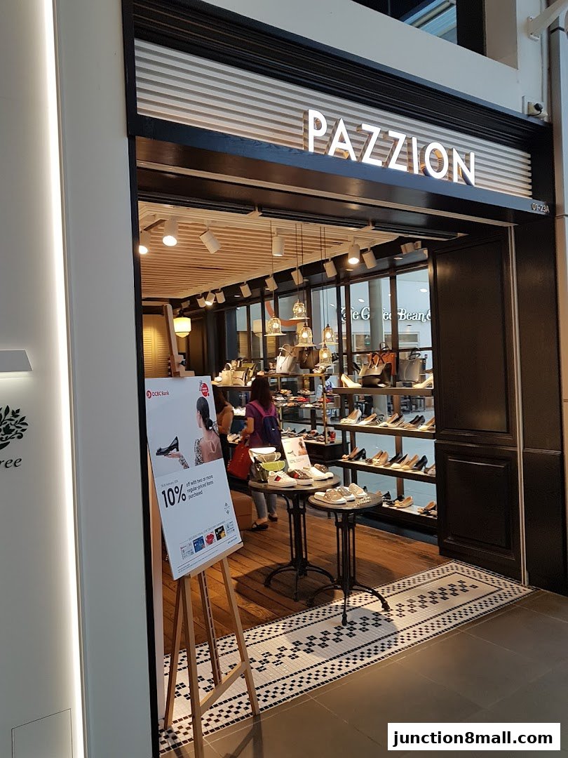 The entrance of PAZZION Junction 8 shoe store, showcasing stylish footwear and a promotional poster.
