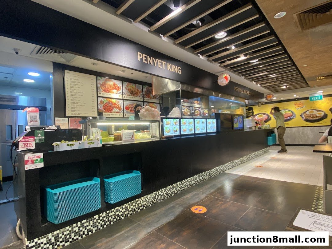 The interior of Penyet King restaurant showing the counter, menu boards, and seating area.