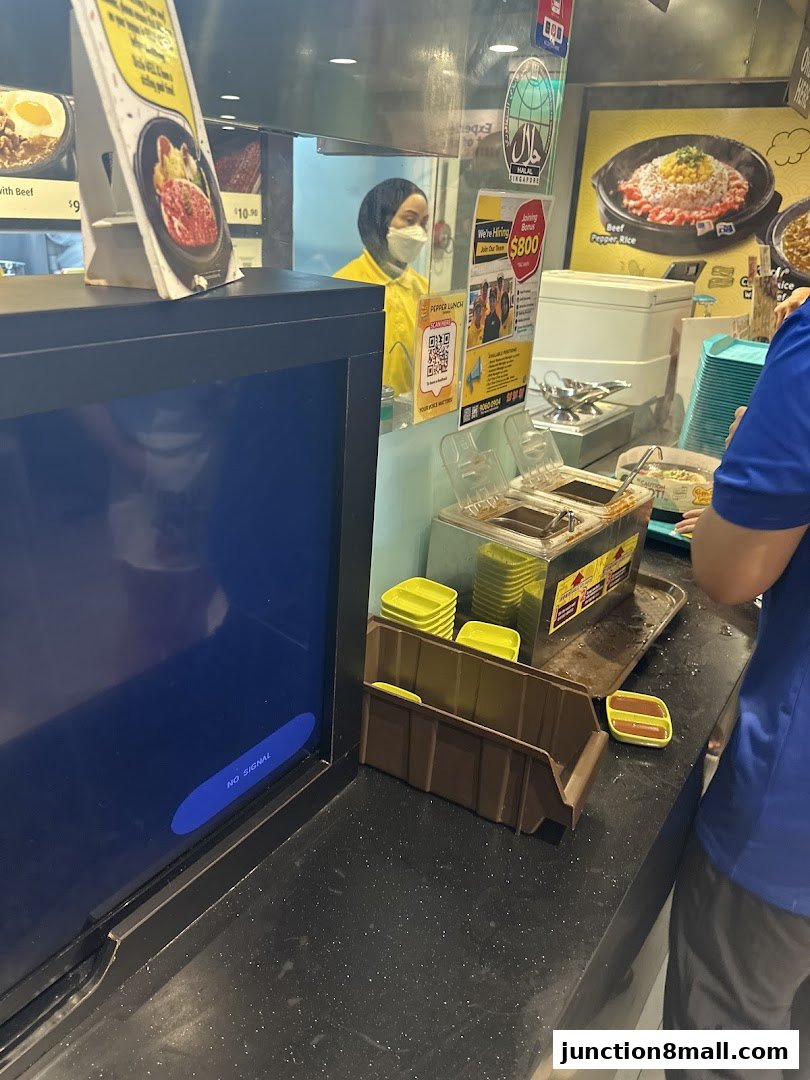 A view of the Pepper Lunch Express counter with staff and food displays.