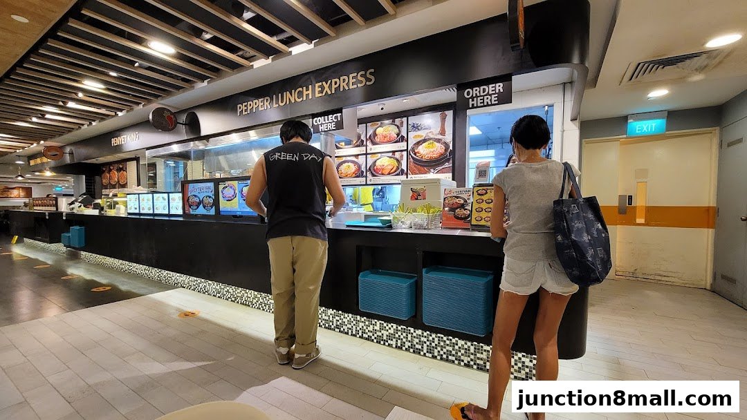 Customers ordering at the Pepper Lunch Express counter in a food court.