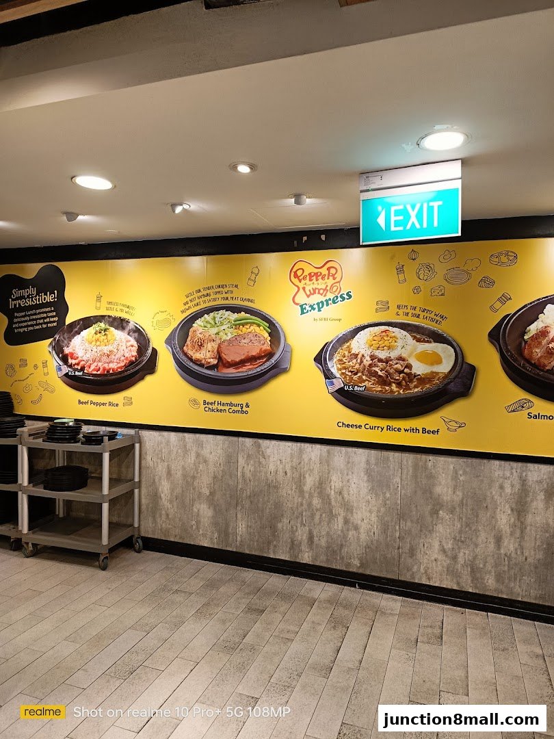 A wall display showcasing Pepper Lunch Express's signature sizzling hot plate dishes.