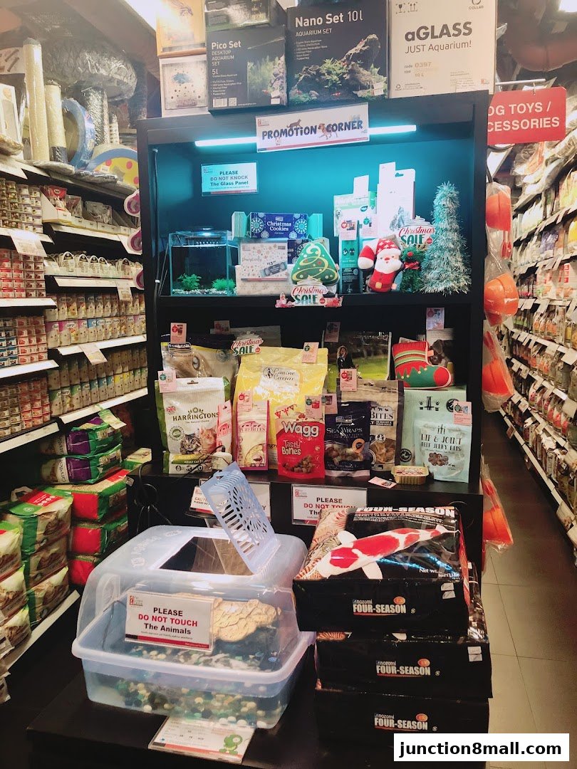 A display of pet supplies including food, toys, and aquarium sets, with a Christmas theme.