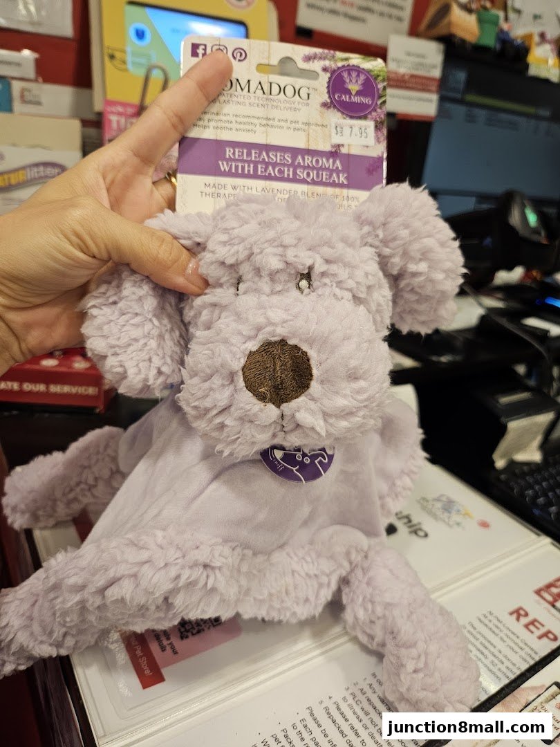 A person holds a lavender-scented plush dog toy that releases aroma with each squeak.