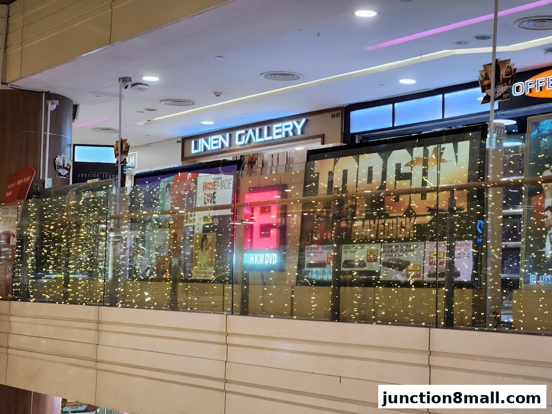 A shop front displaying movie posters and electronics, with festive lights.
