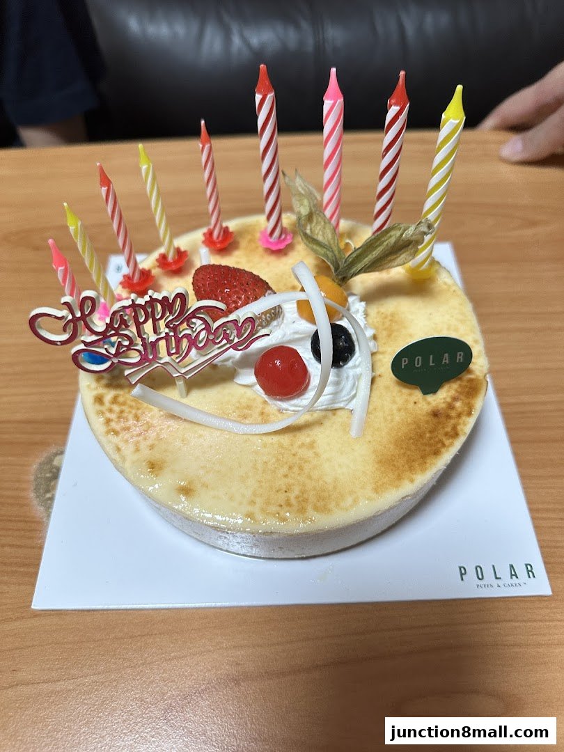 A decorated cake with birthday candles and a 'Happy Birthday' topper.