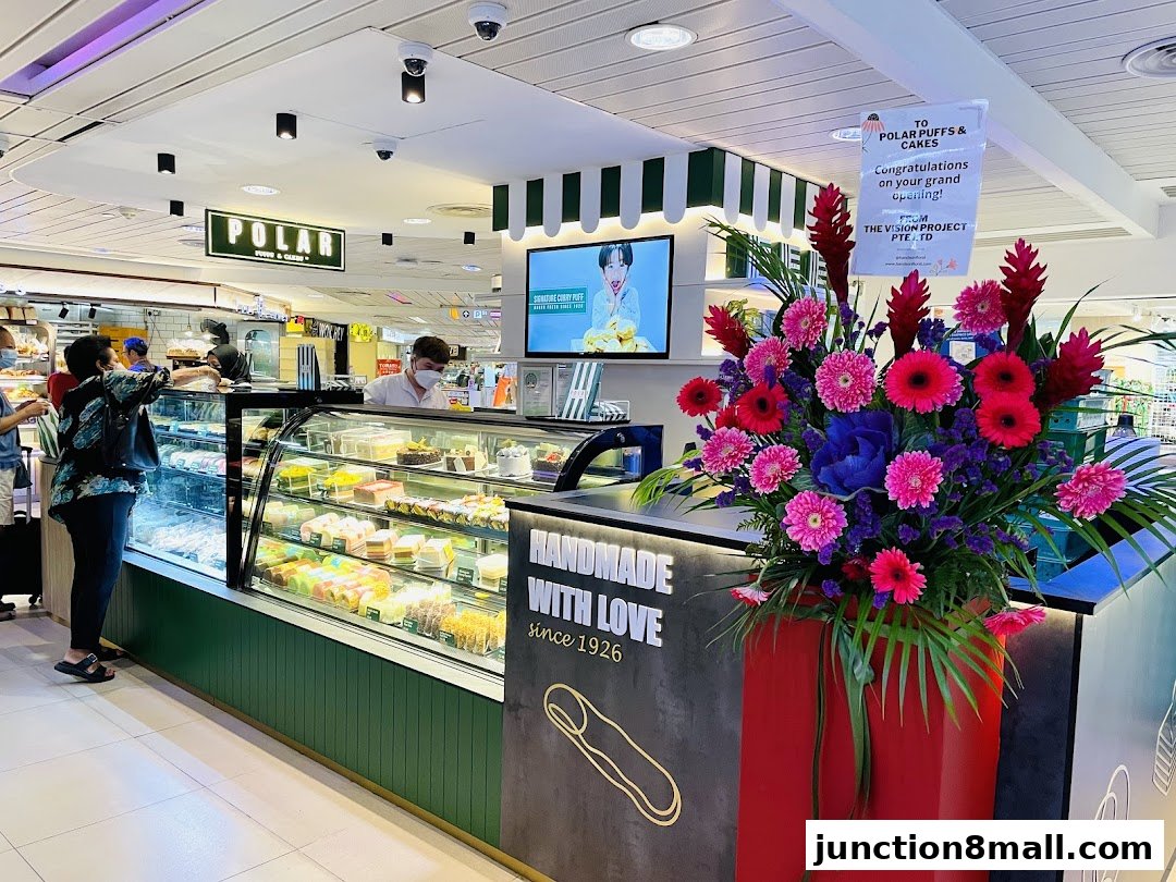 A Polar Puffs & Cakes shop with a display of colorful cakes and a floral arrangement.