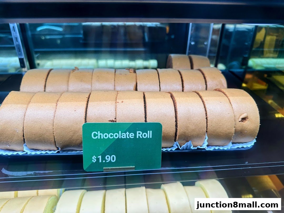 Close-up of chocolate swiss rolls displayed in a bakery case.
