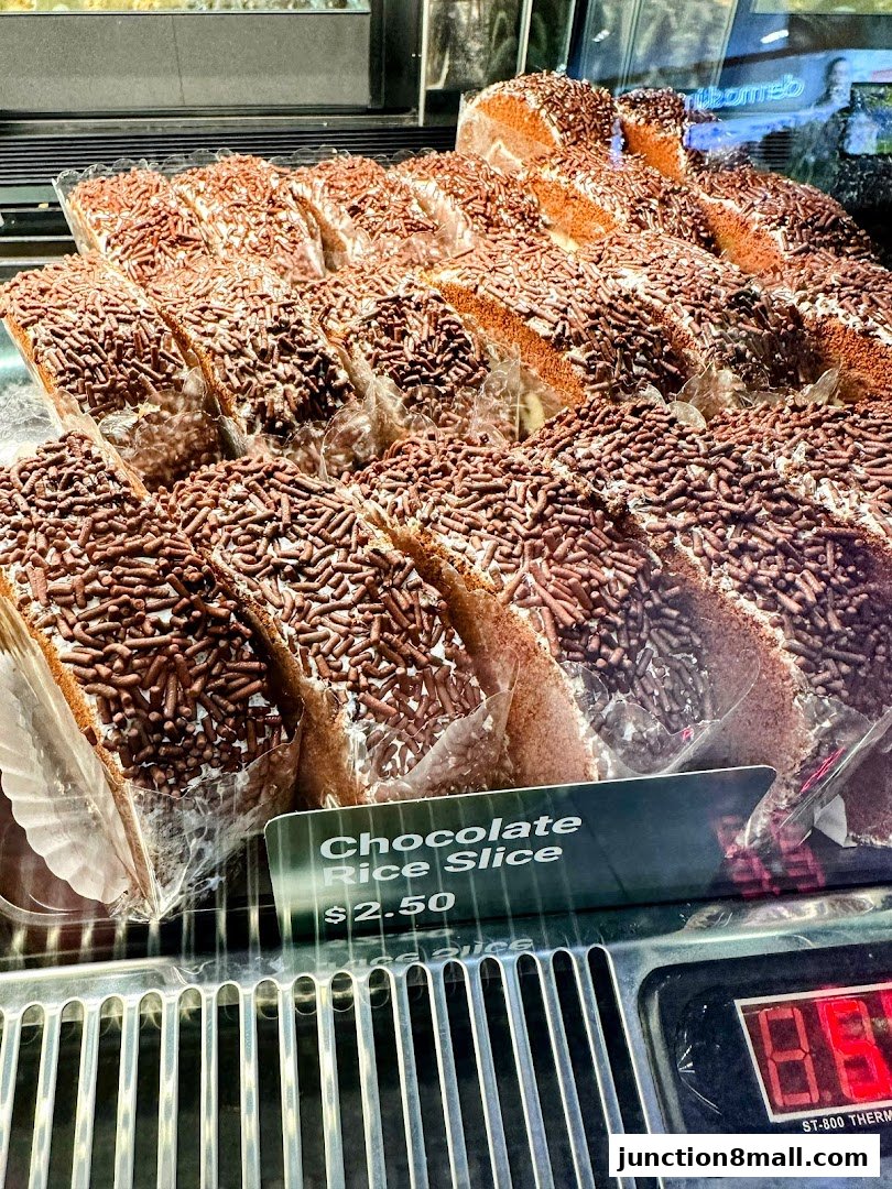Slices of chocolate rice cake topped with chocolate sprinkles displayed in a refrigerated case.