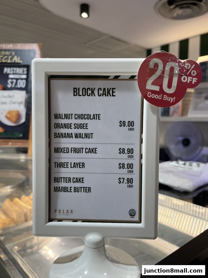 A menu board displaying various block cakes and their prices, with a 20% off sticker.