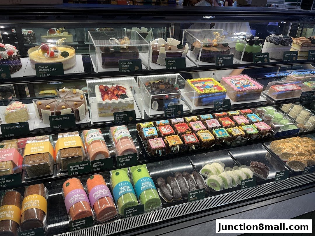 A display case filled with various cakes, swiss rolls, and pastries from Polar Puffs & Cakes.