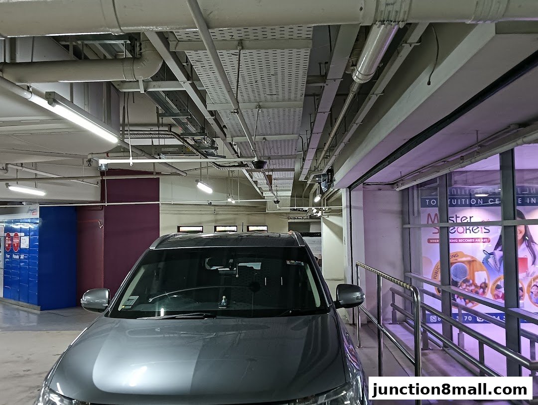 A car parked in a parking lot with a tuition center visible through a glass window.