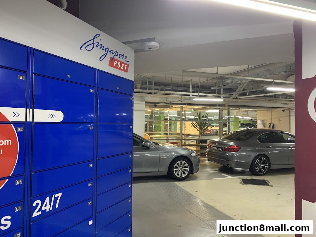 Blue parcel lockers with Singapore Post branding and cars parked nearby.