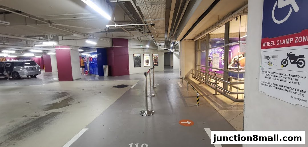 A parking lot with a shop entrance visible on the right and a 'Wheel Clamp Zone' sign.