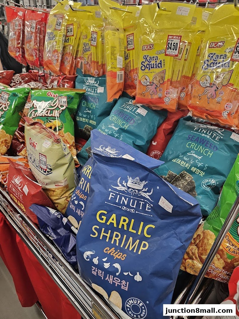 A variety of snack bags, including seaweed crunch and garlic shrimp chips, displayed on a metal rack.