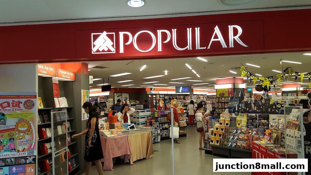 The entrance of a POPULAR bookstore with displays of books and promotional materials.