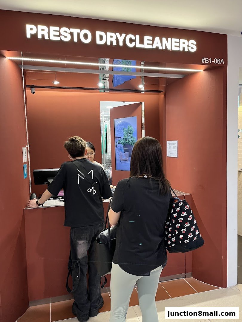 Customers at the counter of Presto Drycleaners, a modern and clean establishment.