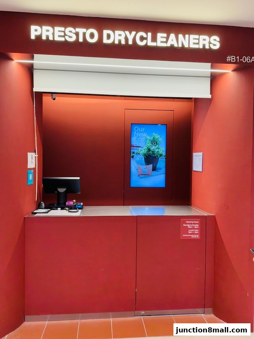 The entrance of Presto Drycleaners with a counter, computer, and digital display.