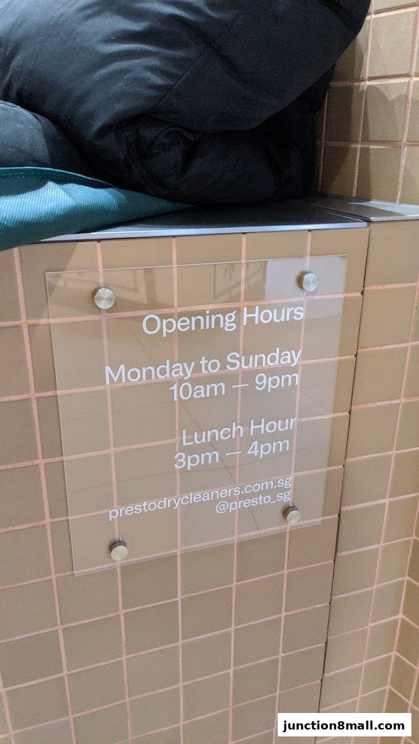 A clear sign displaying the opening hours and contact information for Presto Drycleaners.