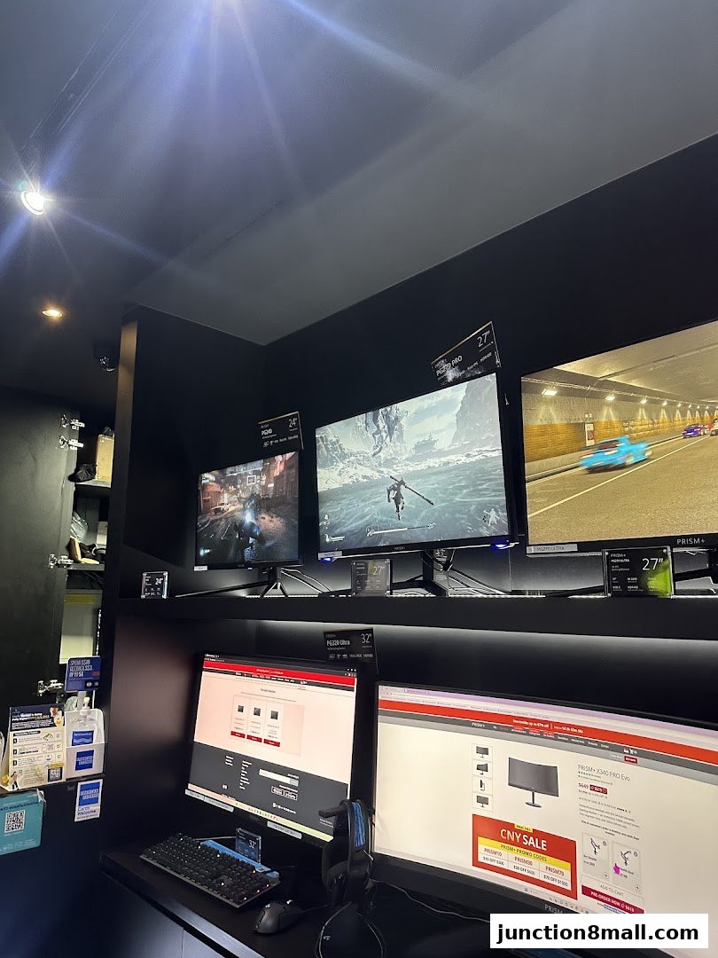 A retail display showcasing multiple computer monitors with gaming and scenic visuals.
