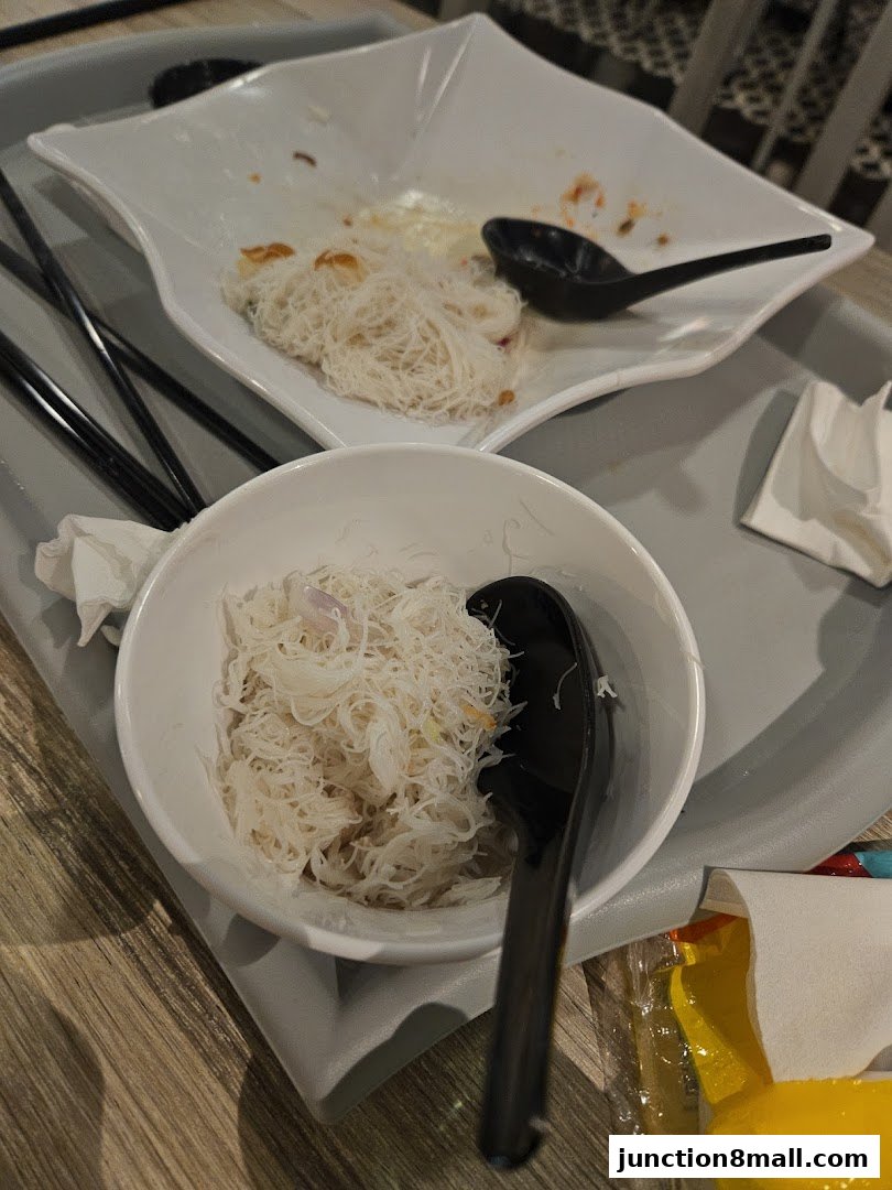 Close-up of leftover noodles and spoons on a tray at Putian Kitchen.