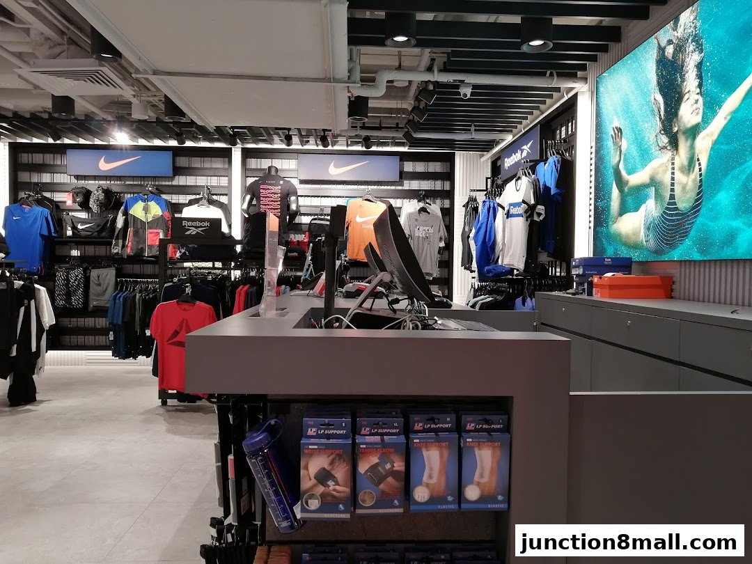 Interior of a sports apparel store with Nike and Reebok branding, displaying clothing and accessories.