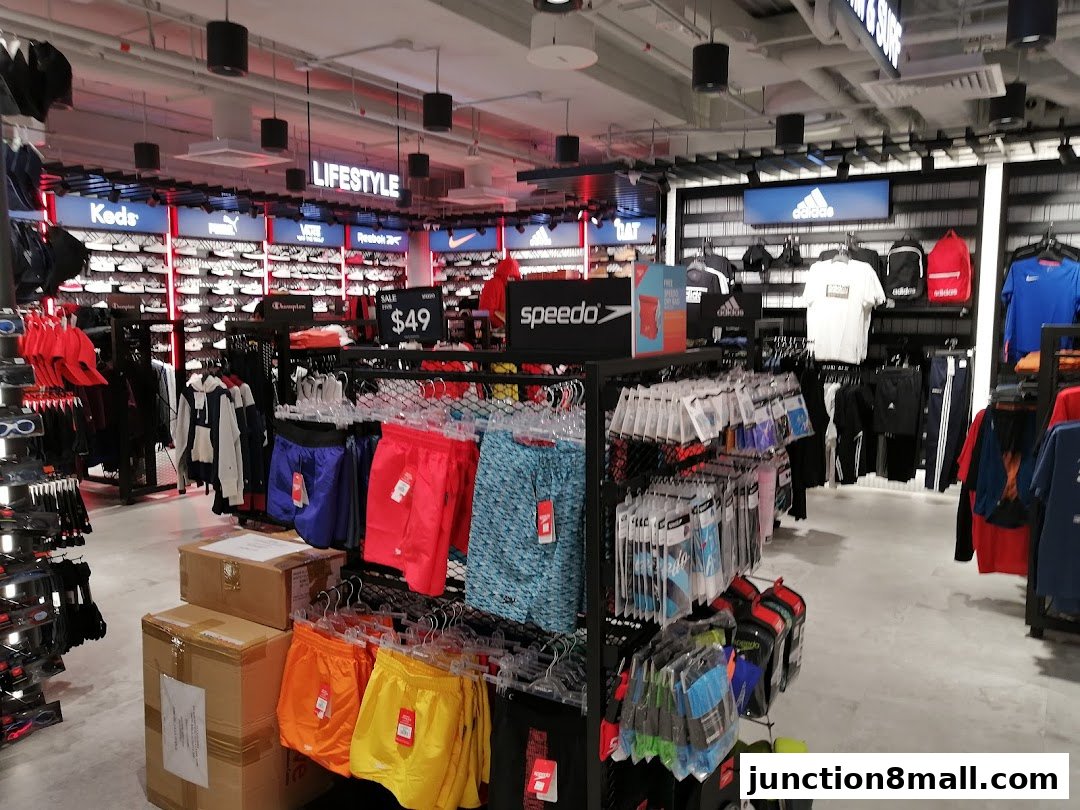 Interior view of a sports apparel store showcasing various brands and merchandise.
