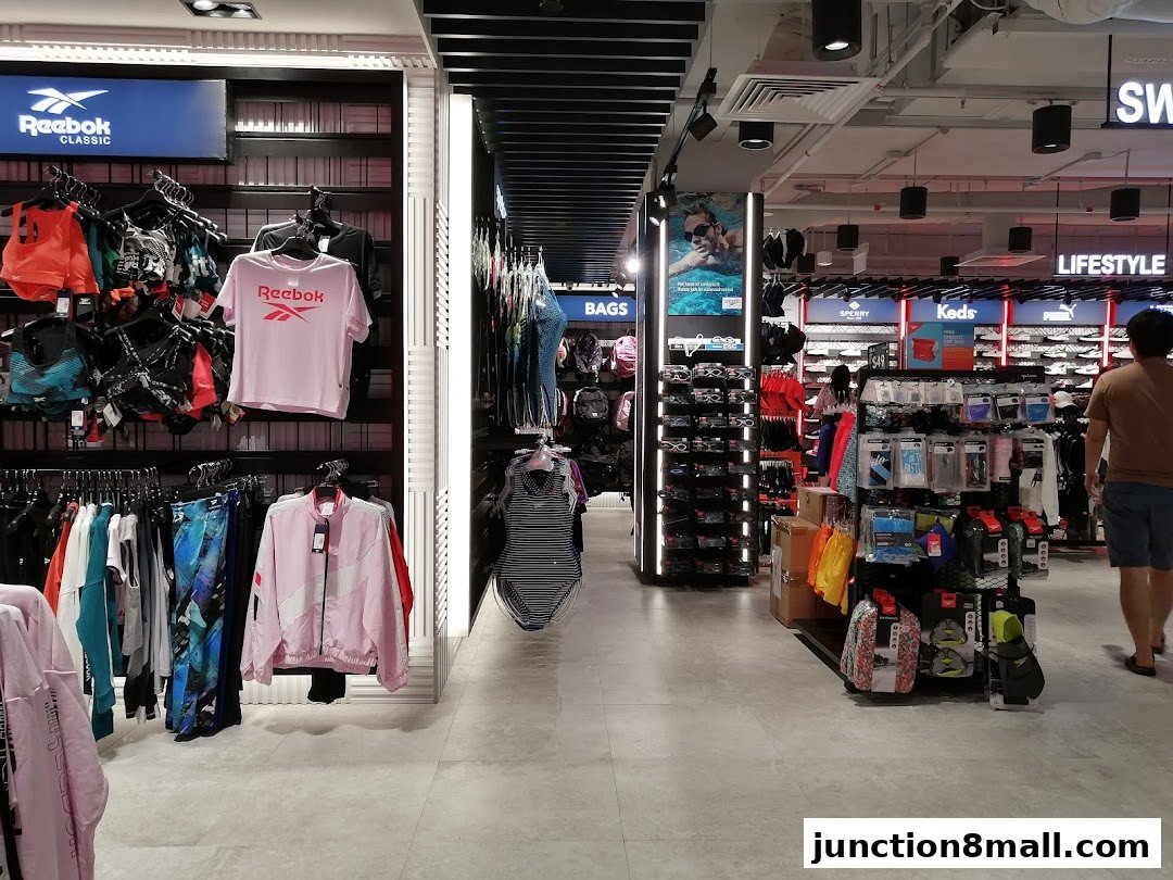 Interior view of a sports apparel store showcasing various brands and clothing items.