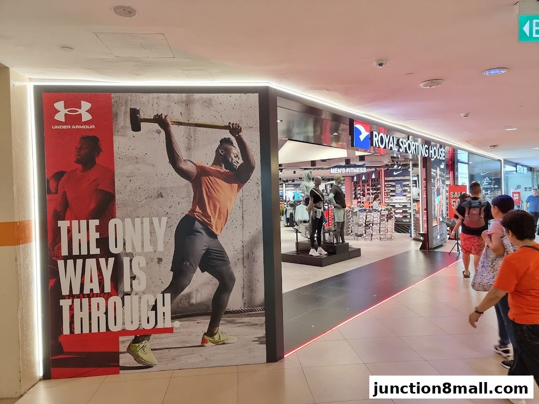 The entrance of Royal Sporting House, featuring an Under Armour advertisement and mannequins.