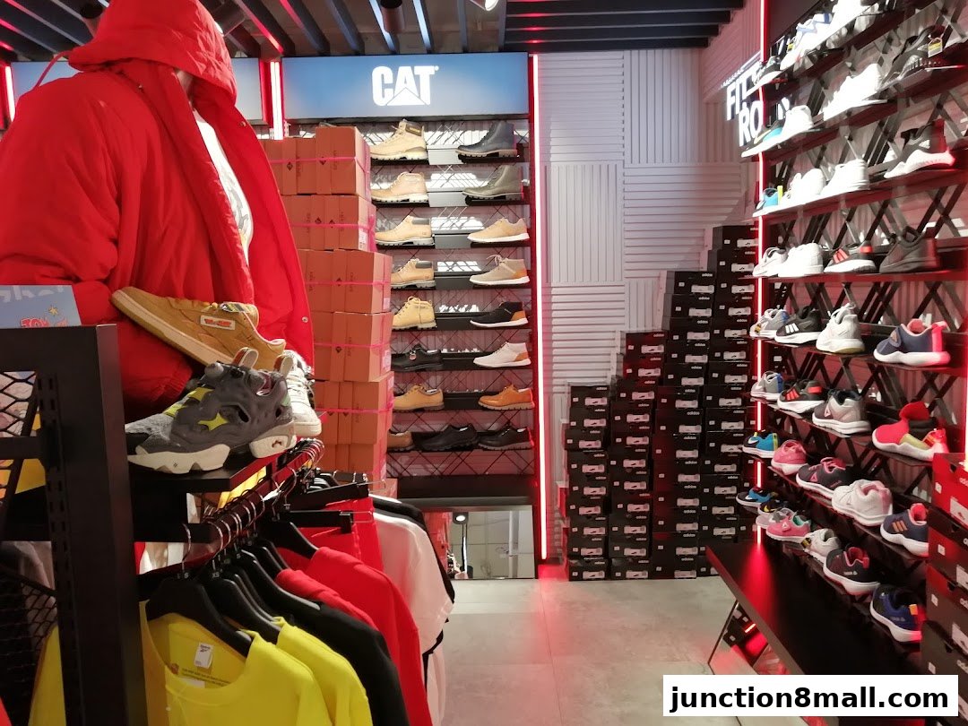 Interior of a sports apparel store with shoes and clothing displayed on shelves and racks.