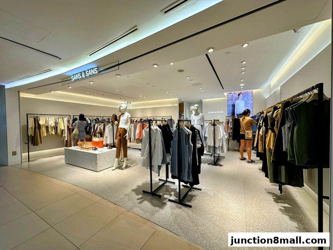 Interior view of a modern clothing store with racks of apparel and mannequins.
