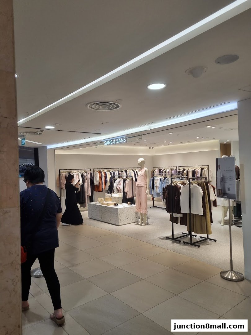 Interior view of a clothing store with racks of apparel and mannequins.
