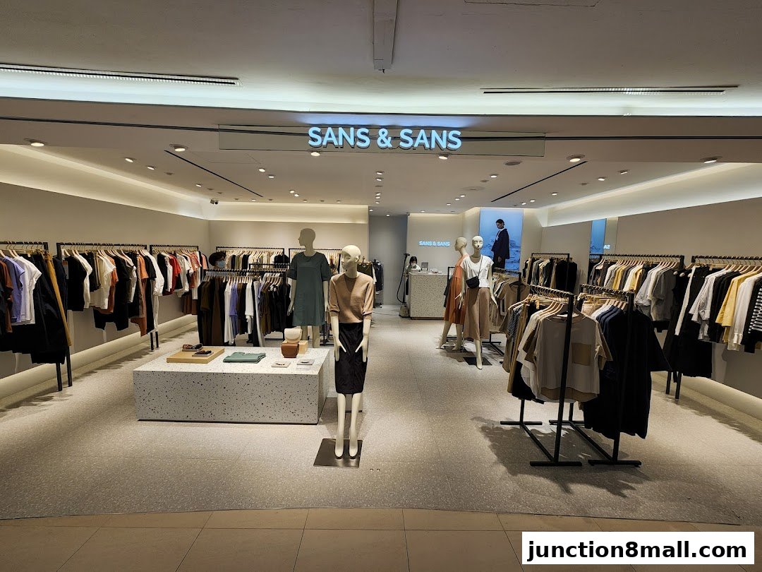 Interior view of a modern clothing store with mannequins and racks of apparel.