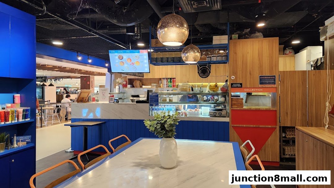 Interior view of a modern cafe with blue and wood accents, featuring a counter and seating.