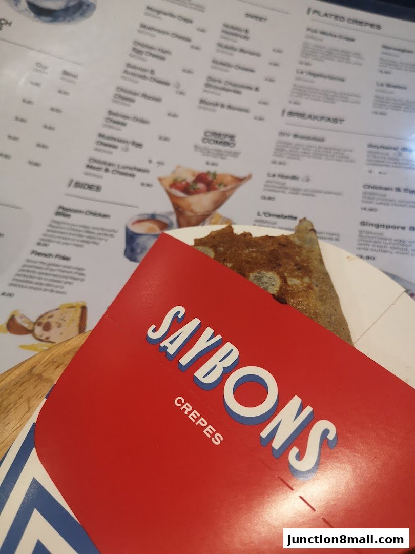A close-up of a Saybons Crepes menu with various crepe options and sides.