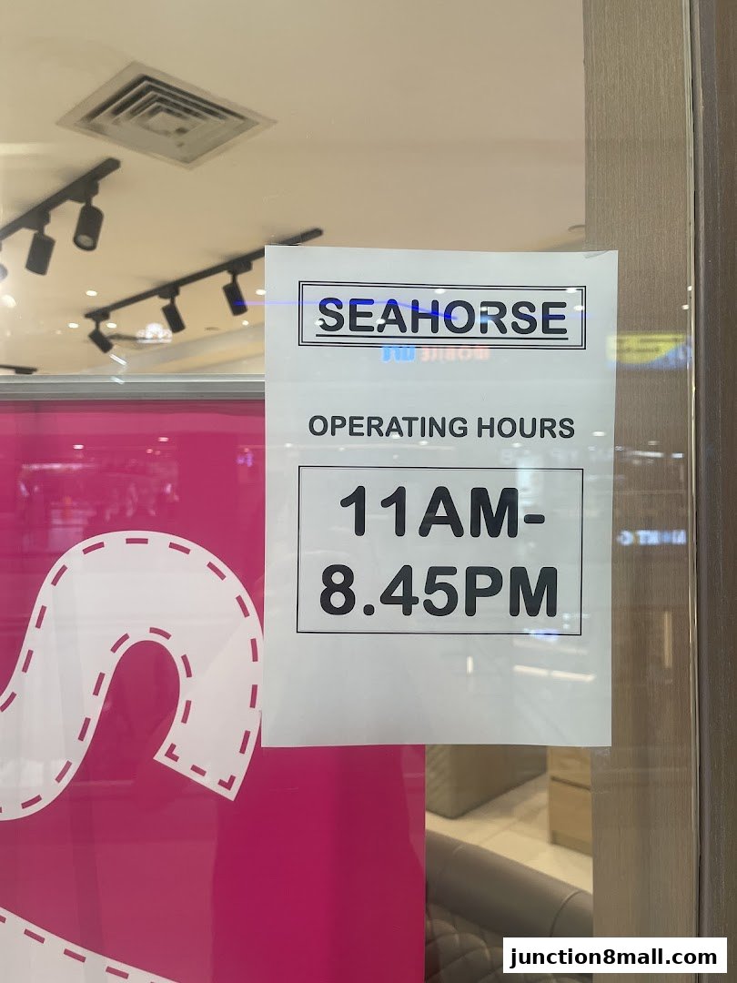 A sign displaying the operating hours for Seahorse Junction 8.
