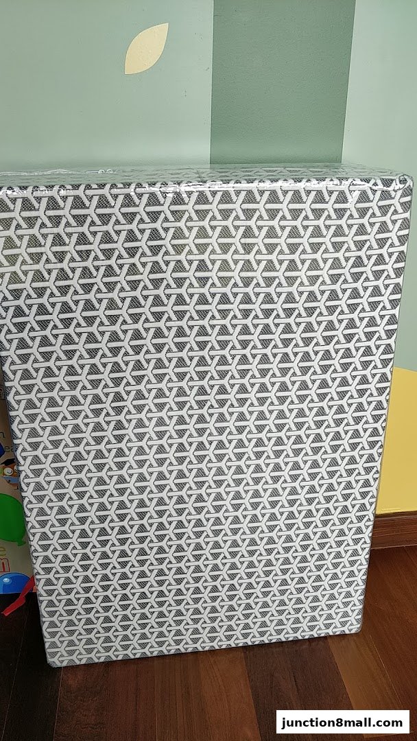 A tall, rectangular object wrapped in plastic with a geometric pattern.