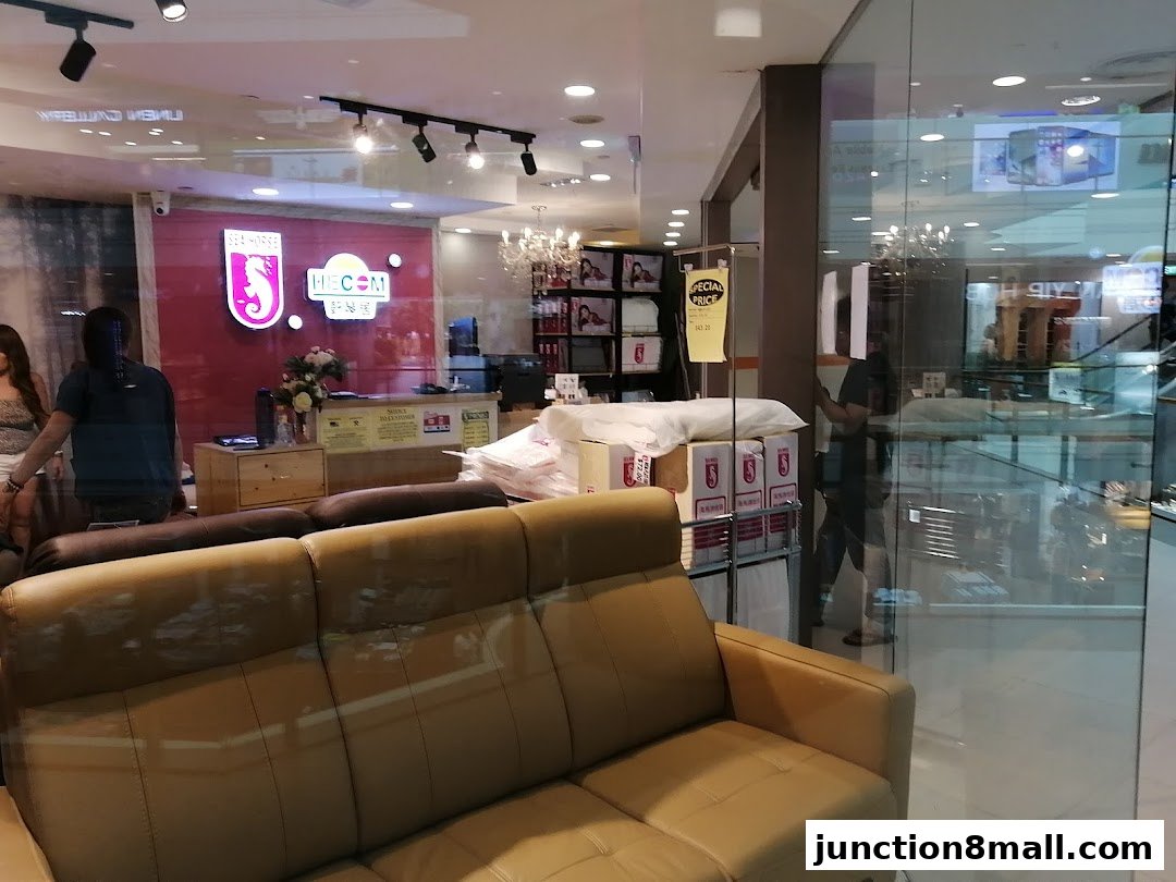 Interior view of a furniture store with sofas and a reception area.