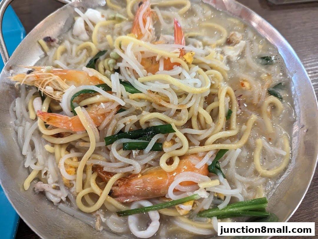 A close-up shot of a delicious seafood noodle dish with fresh prawns and vegetables.