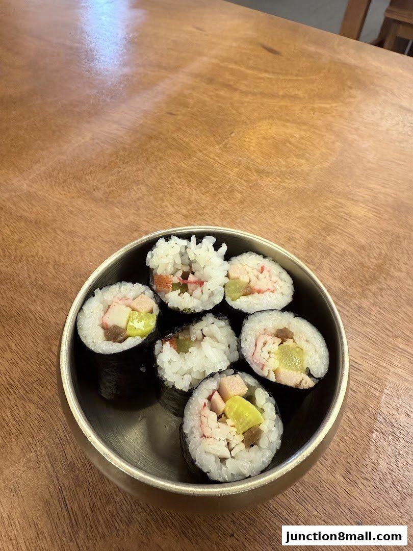A bowl of Korean kimbap rolls filled with rice, vegetables, and imitation crab meat.