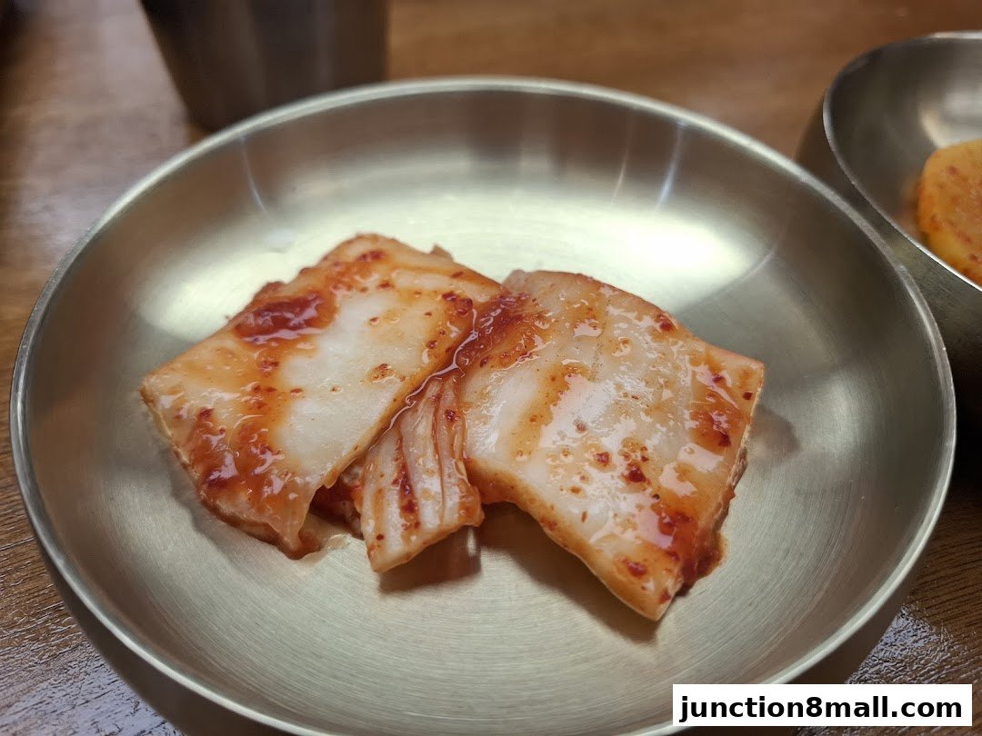 A close-up shot of kimchi served in a traditional metal bowl.